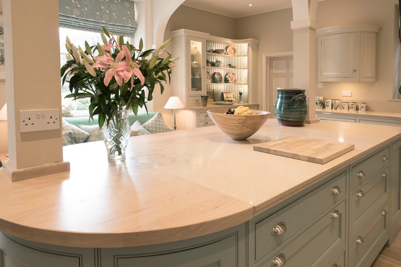 A kitchen counter with a vase of flowers on it.