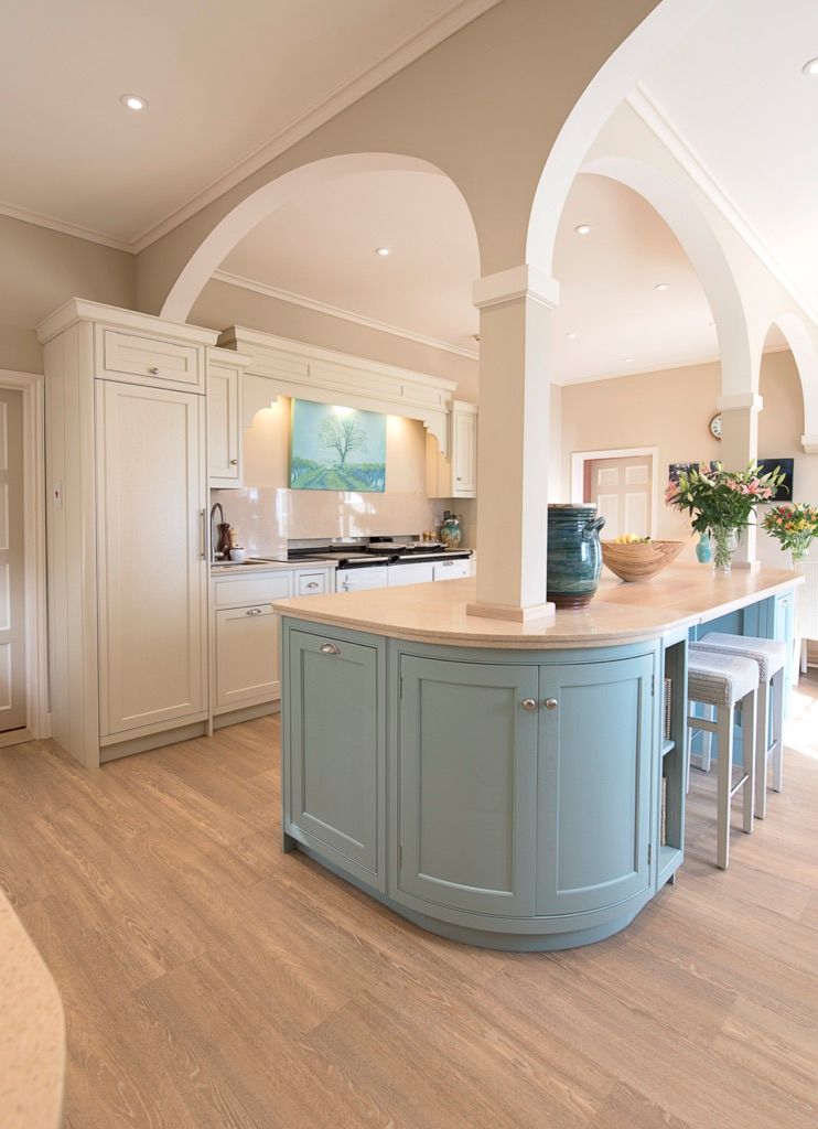 A kitchen with blue cabinets and a large island in the middle.