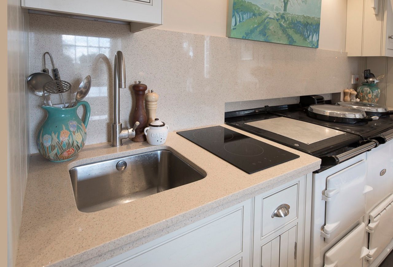 A kitchen with a sink , stove and a painting on the wall.