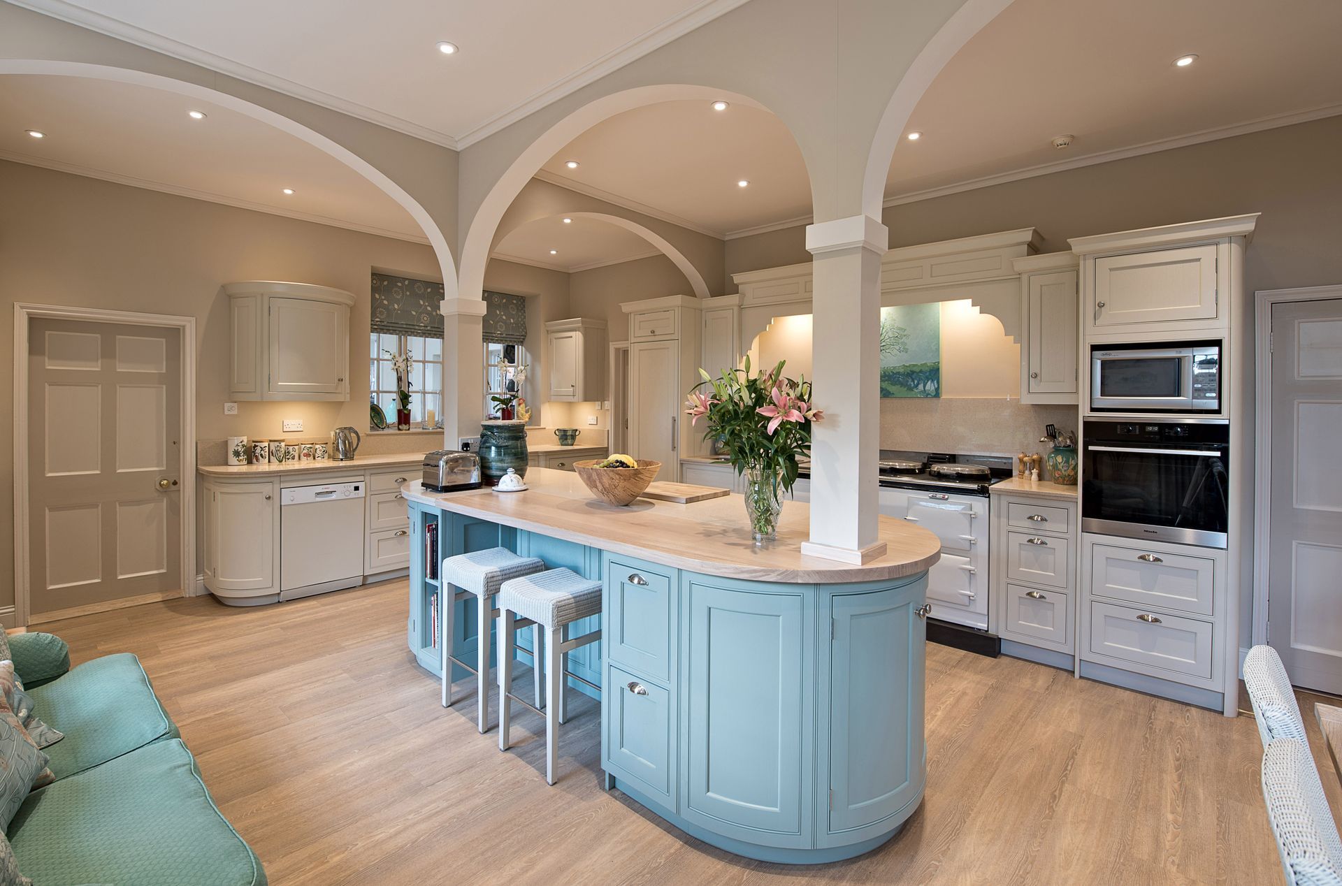 A large kitchen with blue cabinets and a large island in the middle.