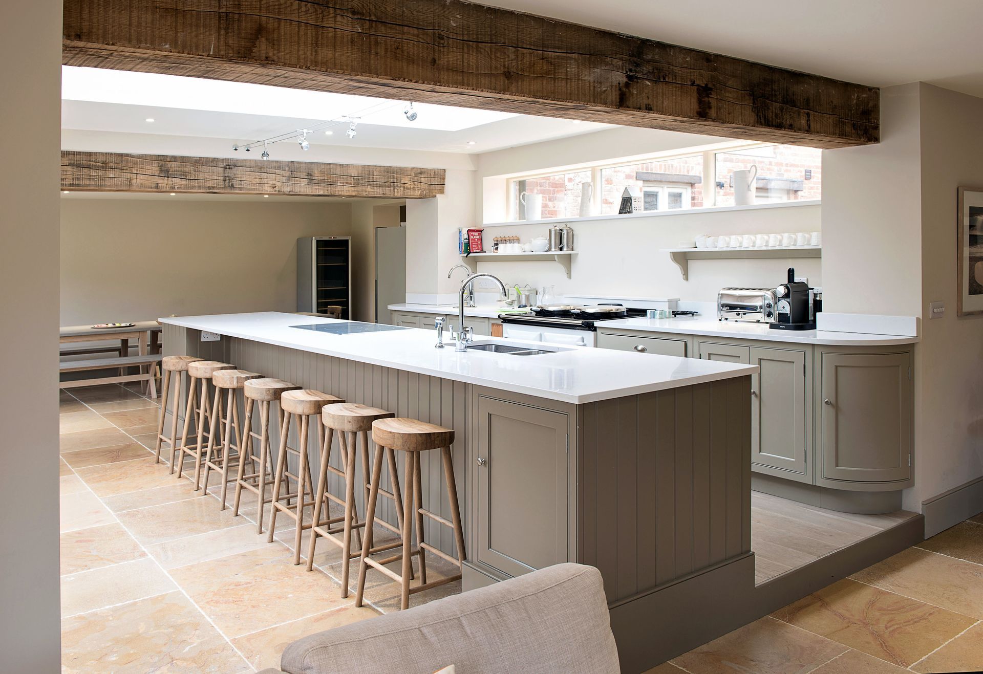 A kitchen with a long island and a lot of stools