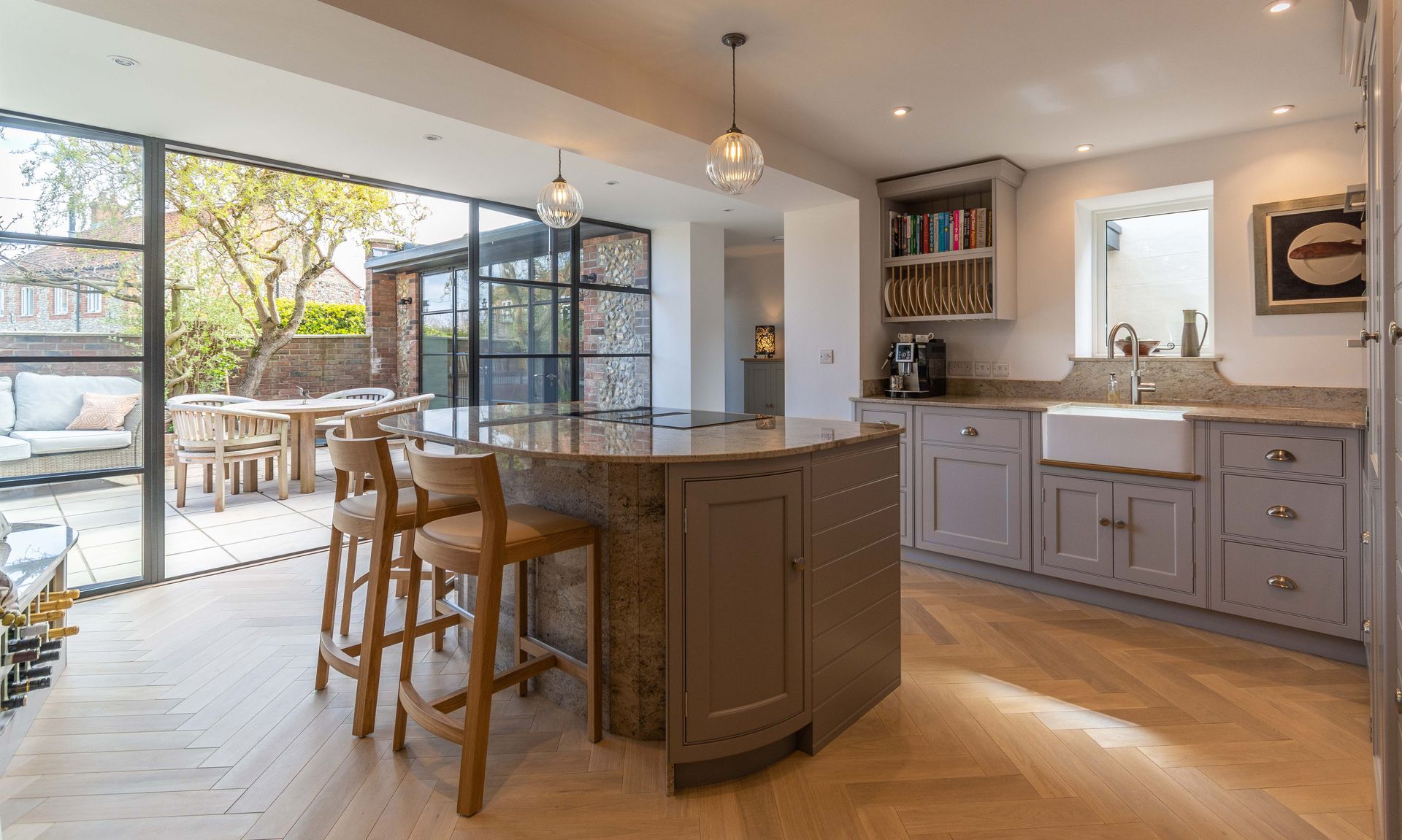 A kitchen with a large island and stools in it.
