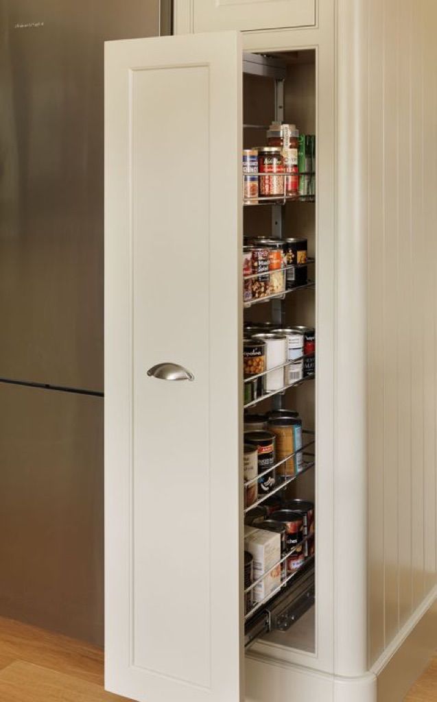 A pantry in a kitchen with the door open and lots of food in it.