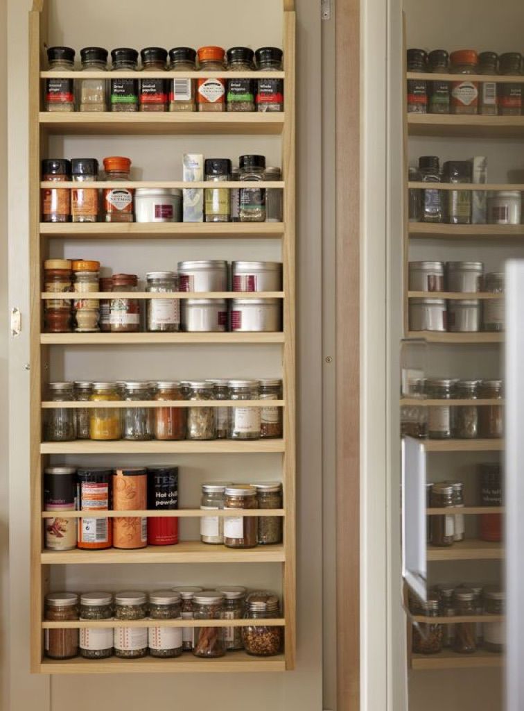 A wooden spice rack filled with jars of spices