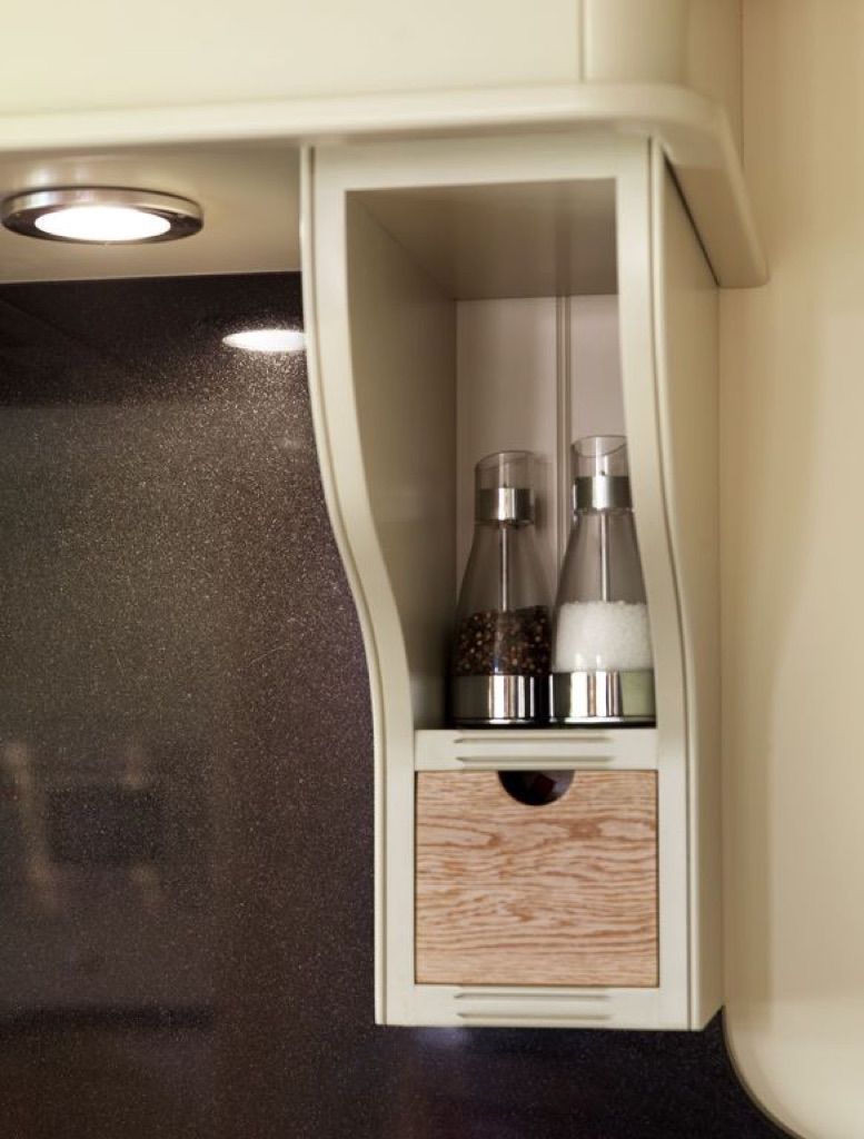 A shelf with two bottles of salt and pepper on it