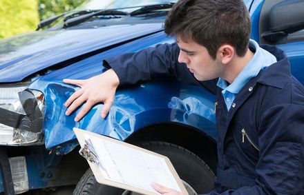 Auto Body Repair — Auto Workshop Mechanic Inspecting Car And Filling In Repair Estimate in Staten Island, NY
