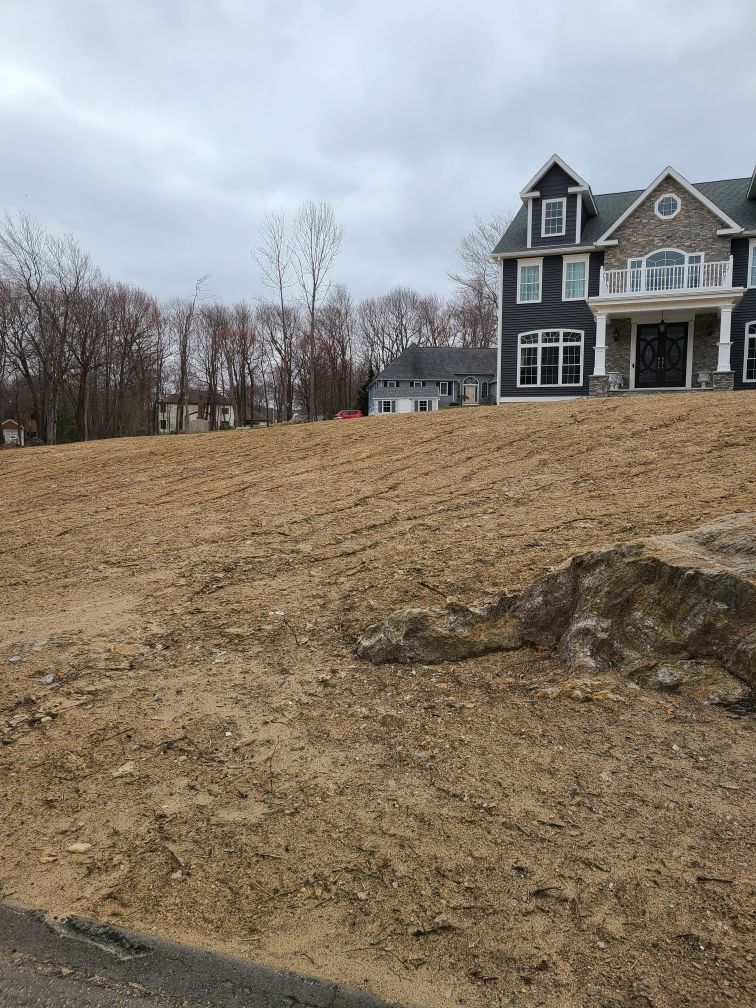 A large house is sitting on top of a dirt hill.