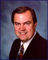 A man in a suit and tie is smiling for the camera.