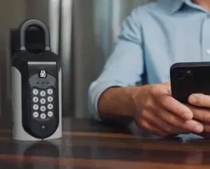 A man is sitting at a table using a cell phone.