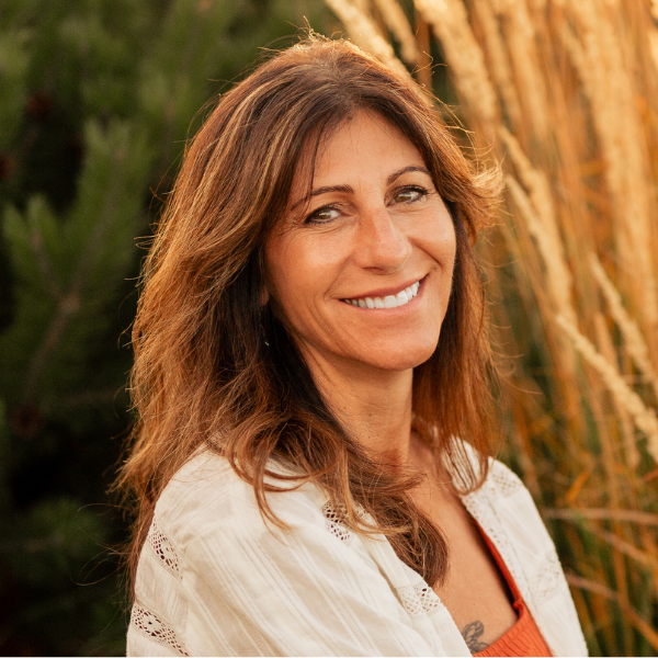 A woman with long blonde hair is smiling for the camera.