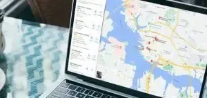A laptop computer with a map on the screen is sitting on a table.