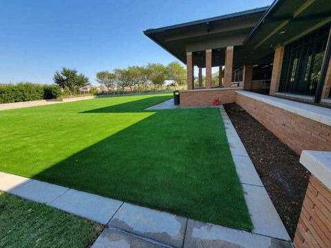 A large lawn with a brick building in the background.