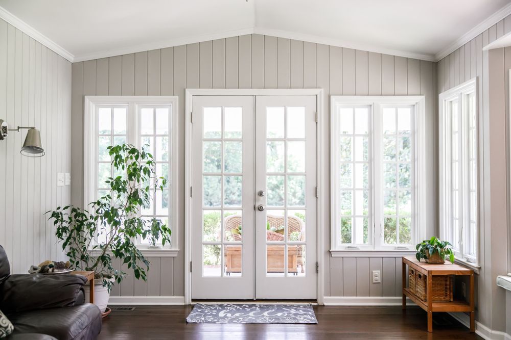 A living room with a lot of windows and a door.