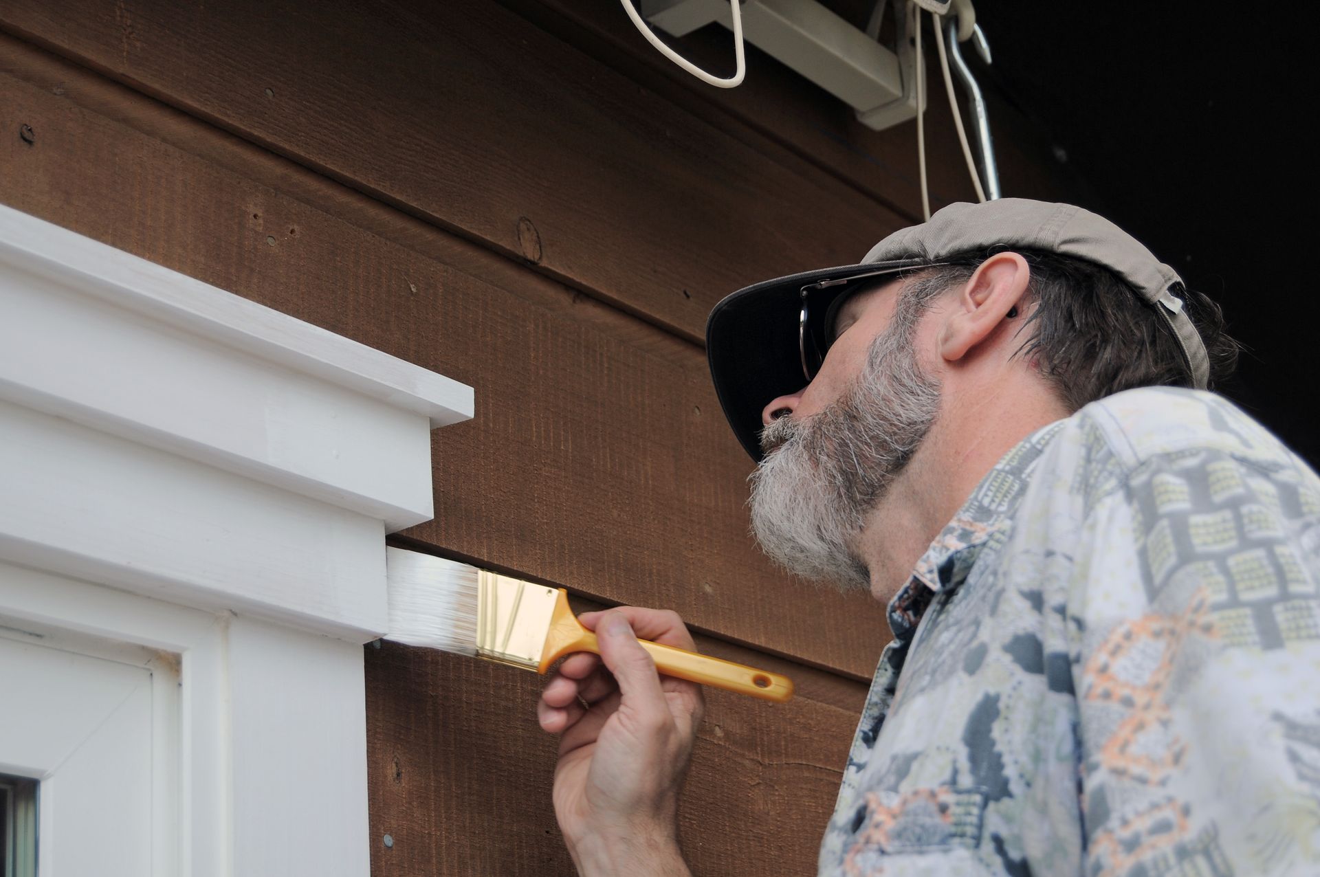 A man is painting a window with a brush.