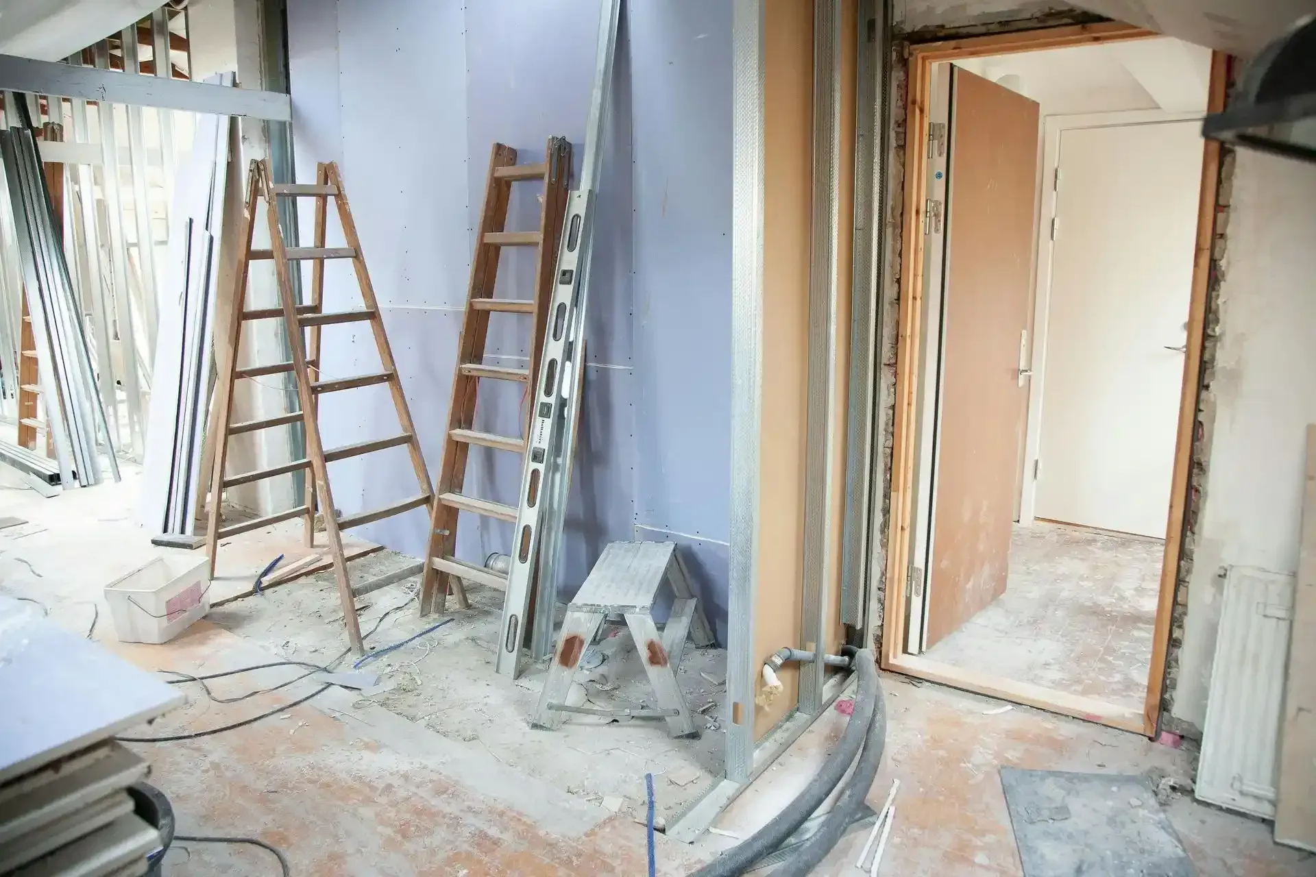 A room under construction with a ladder and a stool.