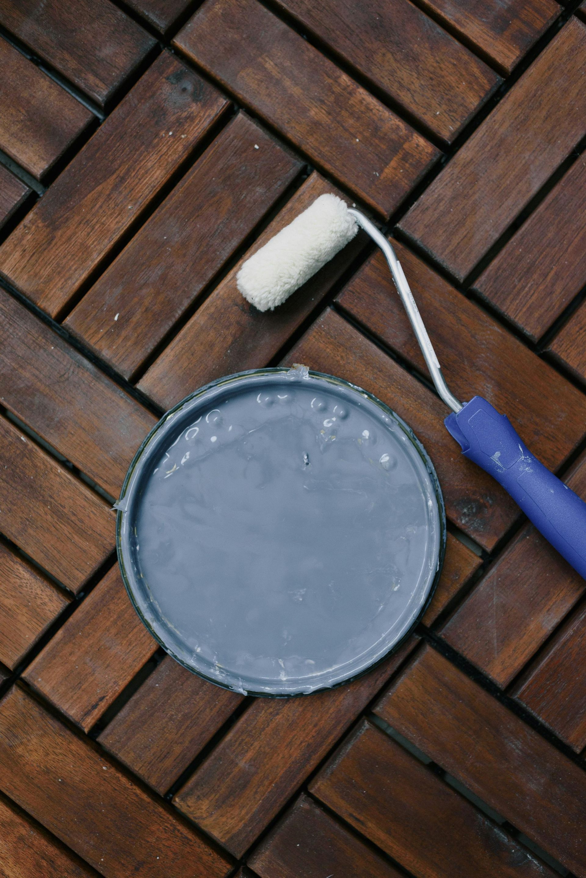 A blue paint can with a brush in it