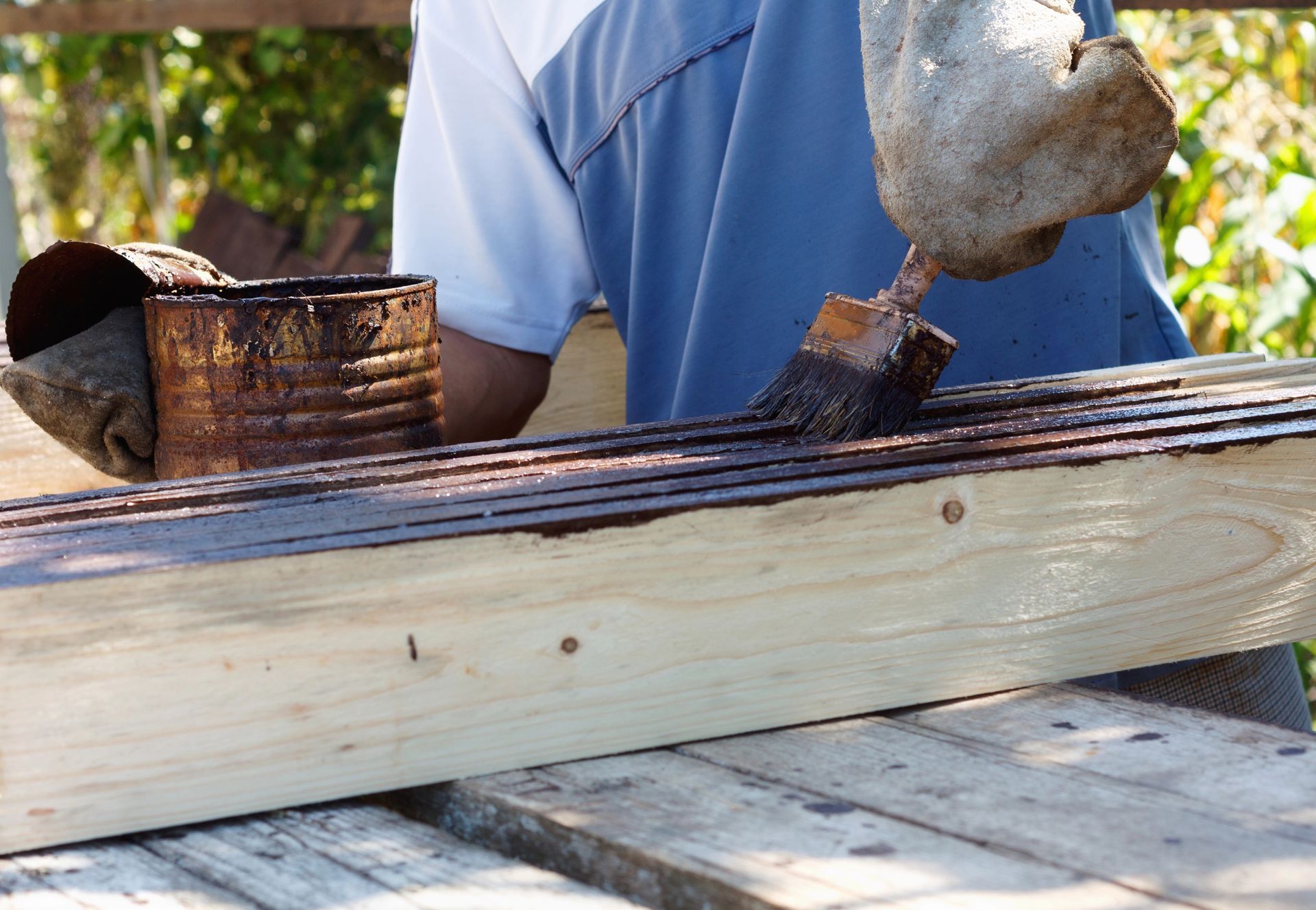 A person is painting a piece of wood with a brush.