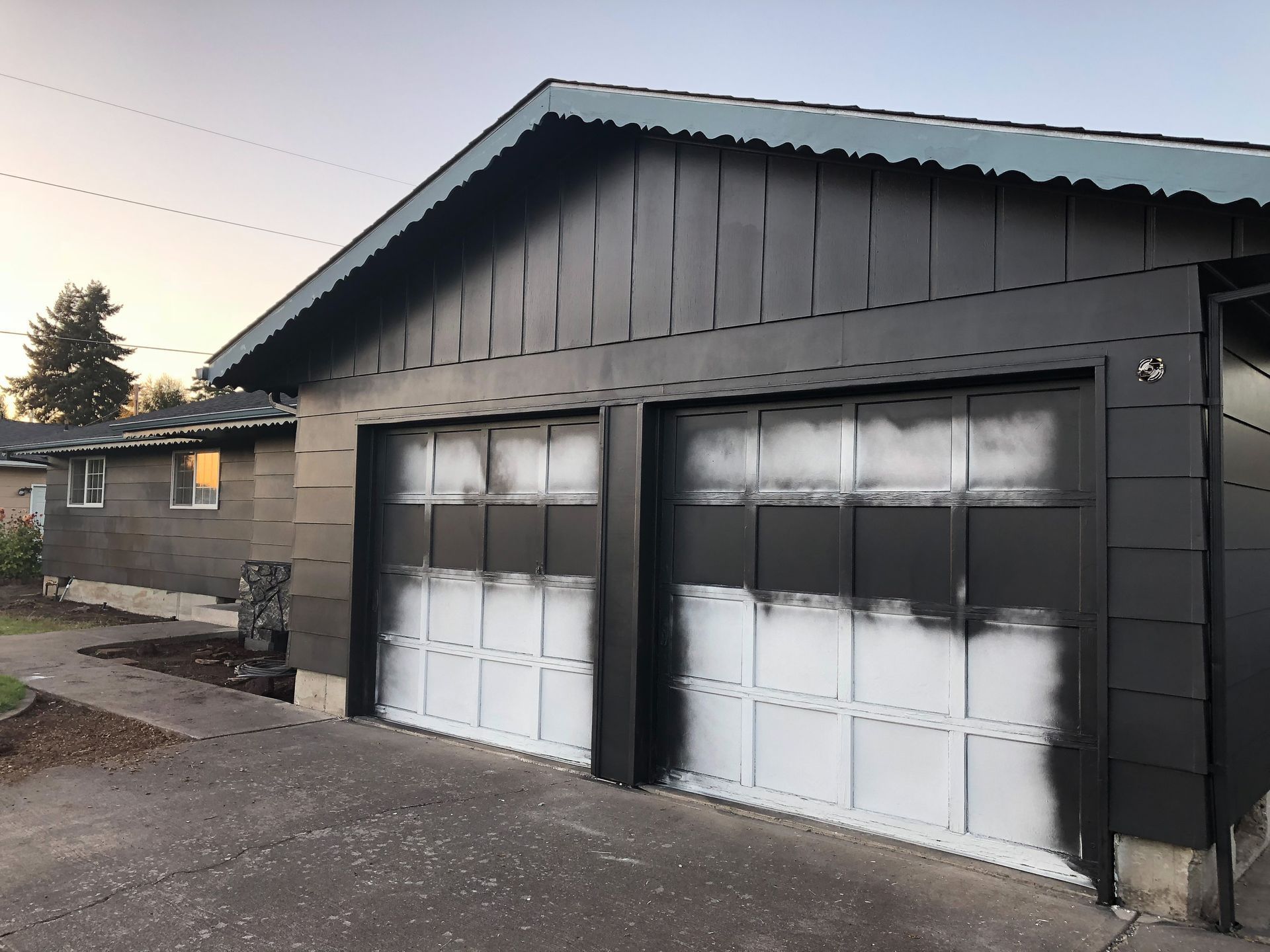 A black and white garage door with a blue roof