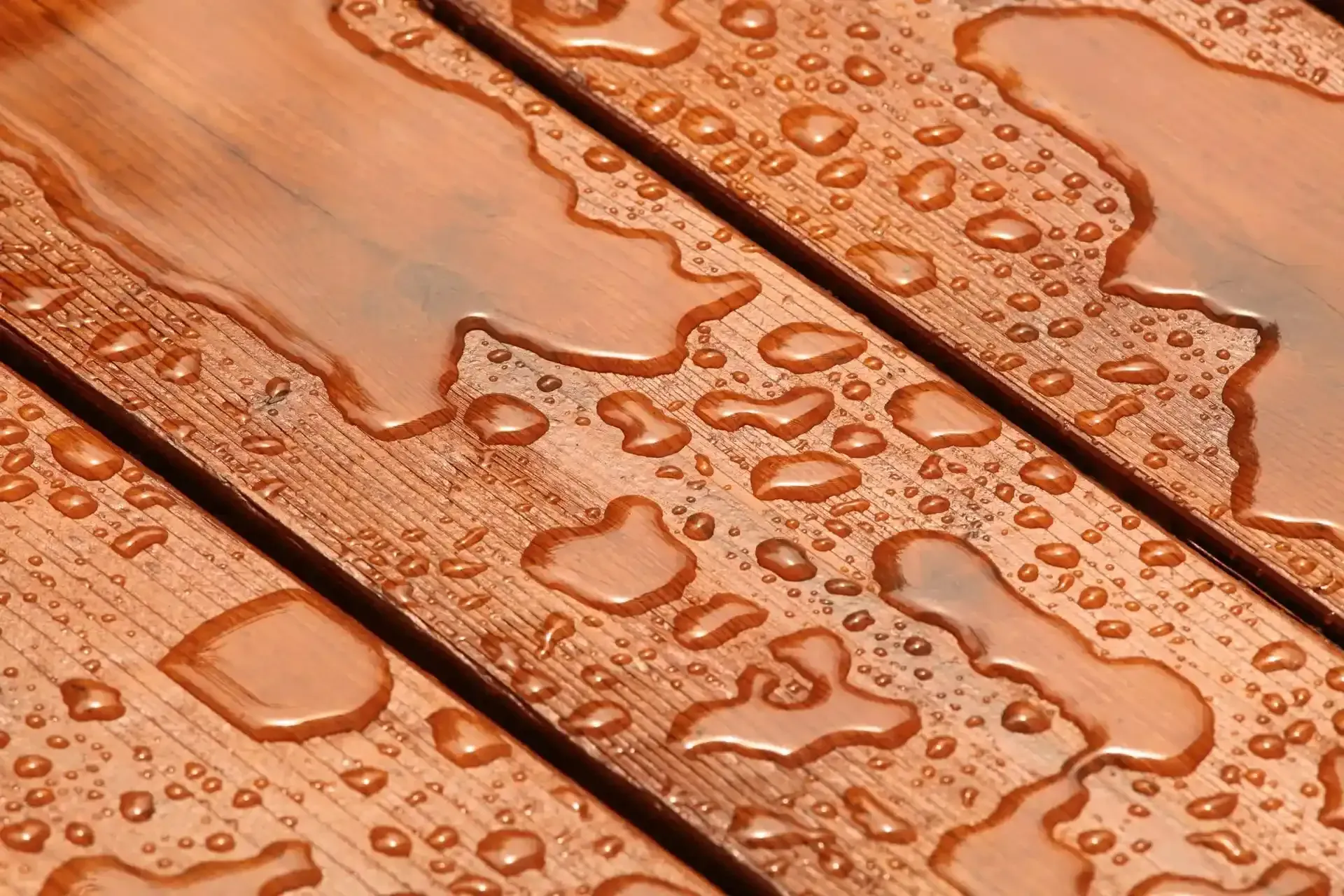 A close up of a wooden surface with water drops on it