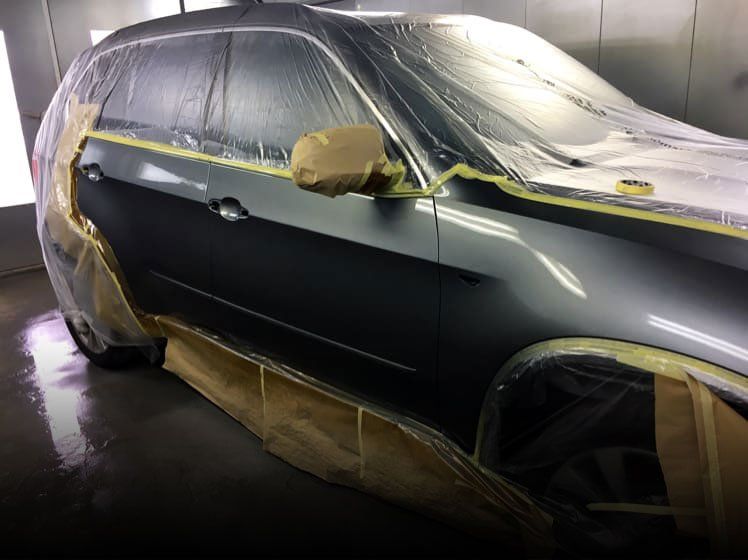 silver car having side panel re-sprayed