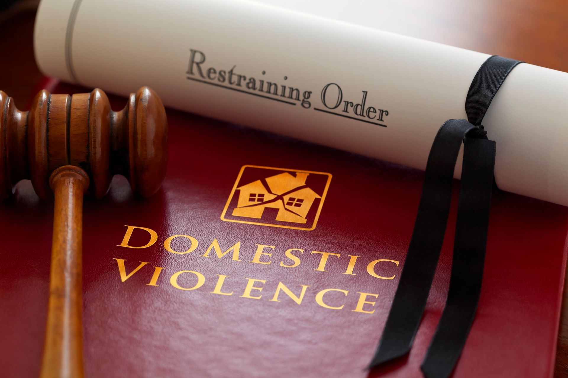 Gavel, rolled restraining order, and a book titled 