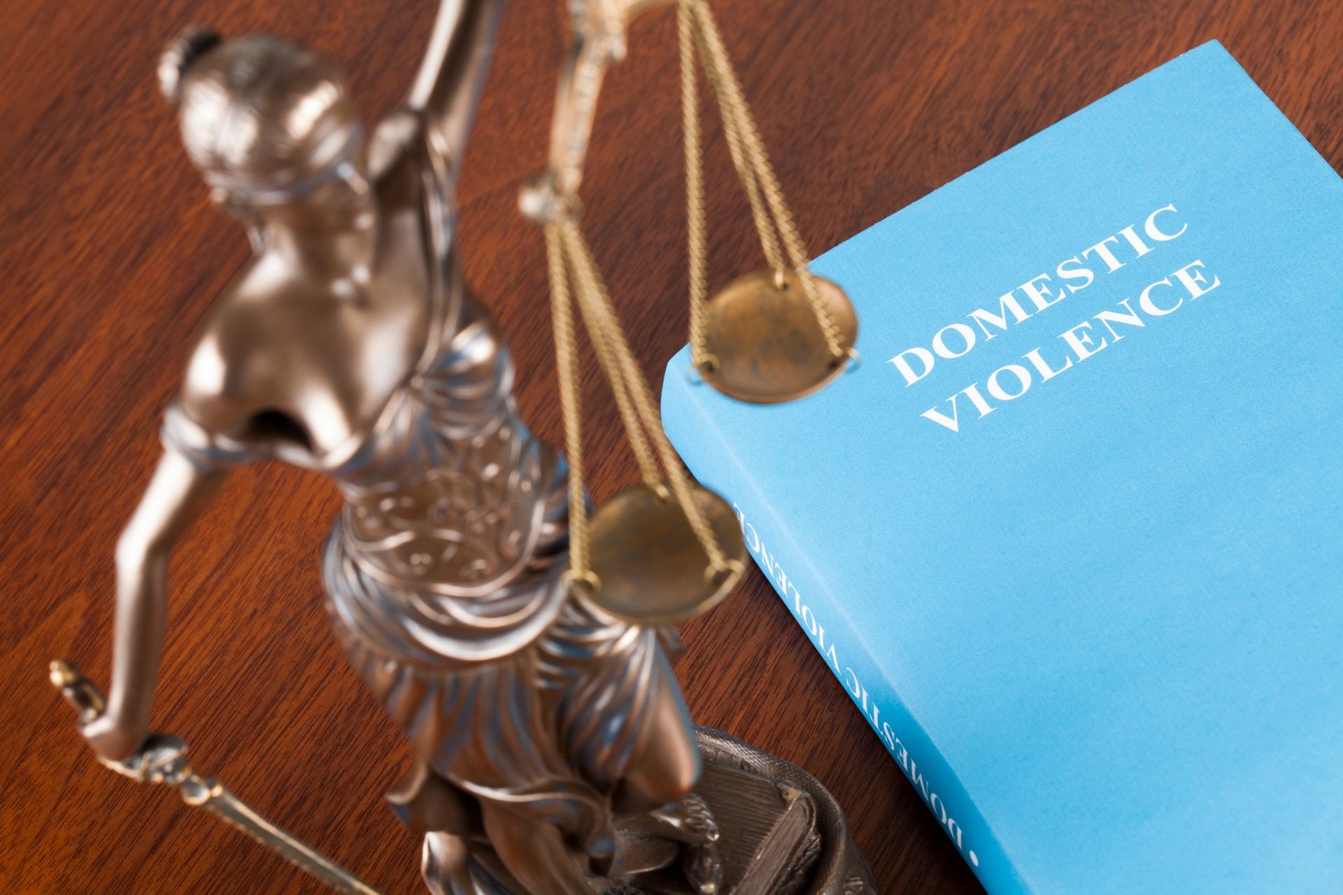 Statue of Lady Justice next to a book titled 