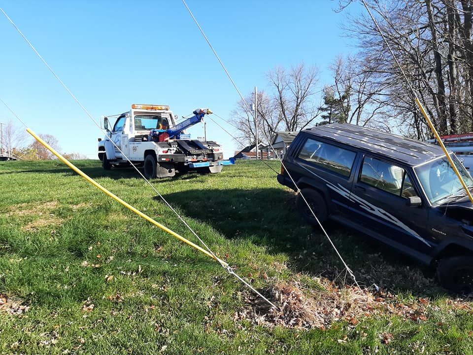 A tow truck is towing a car that has fallen off the road.