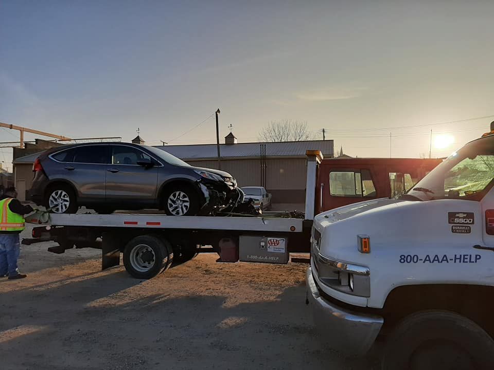A car is being towed by a tow truck.