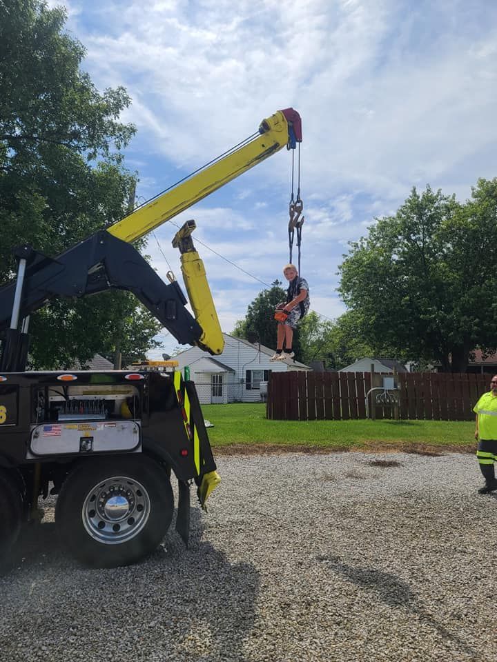 A man is being lifted by a crane on top of a truck.