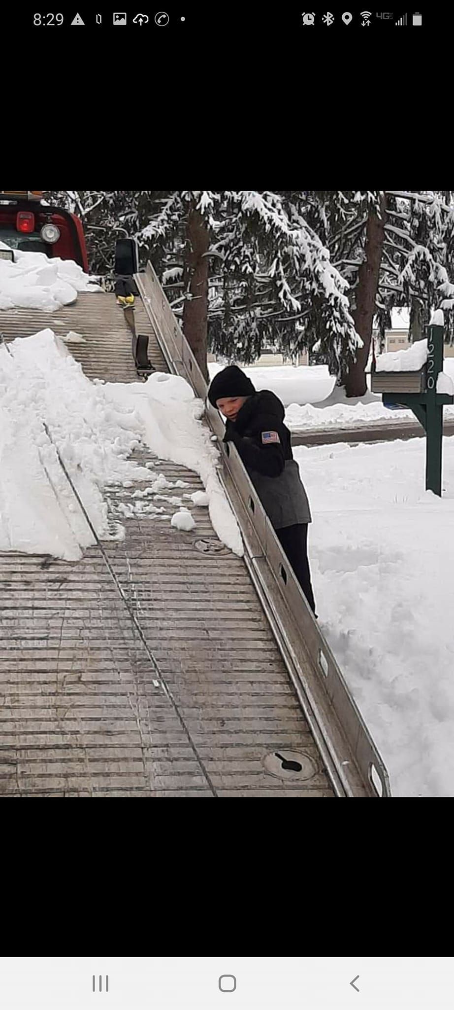 A person is standing on a wooden ramp in the snow.