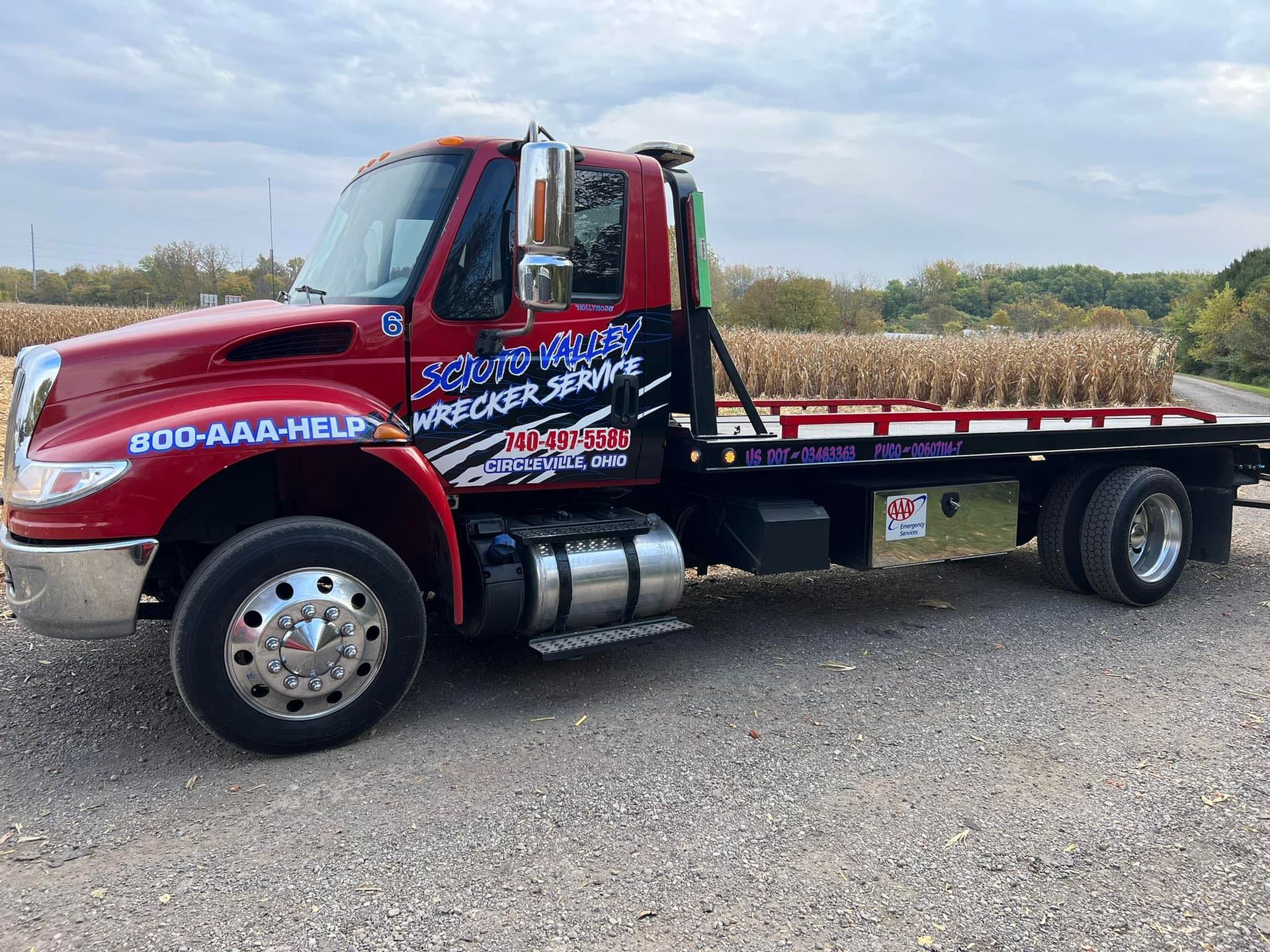 A red tow truck is parked on the side of the road.