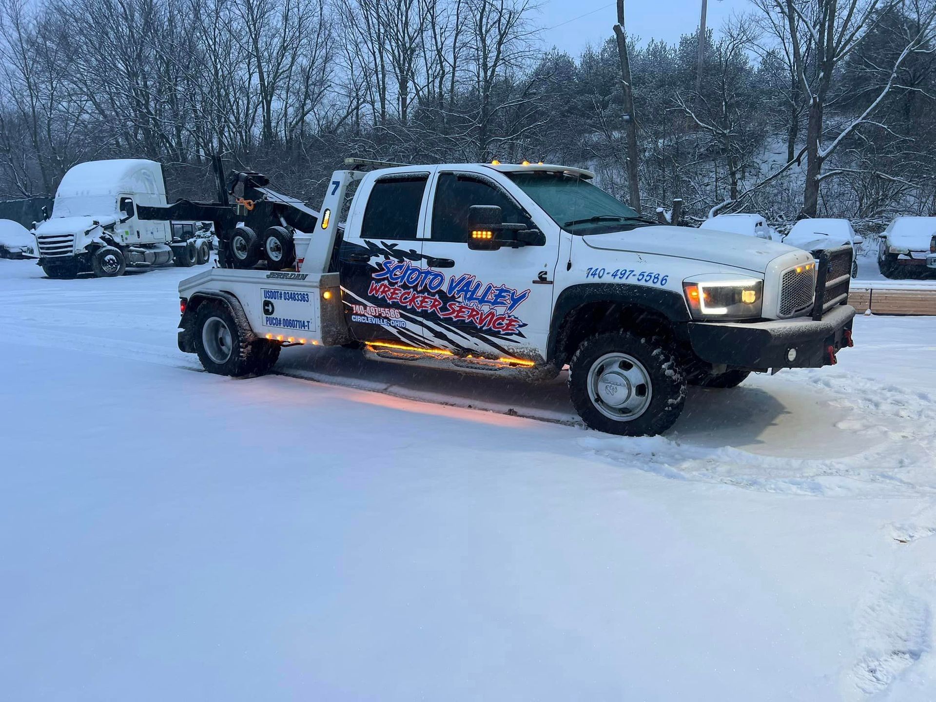 A red tow truck with a white truck on the back of it.