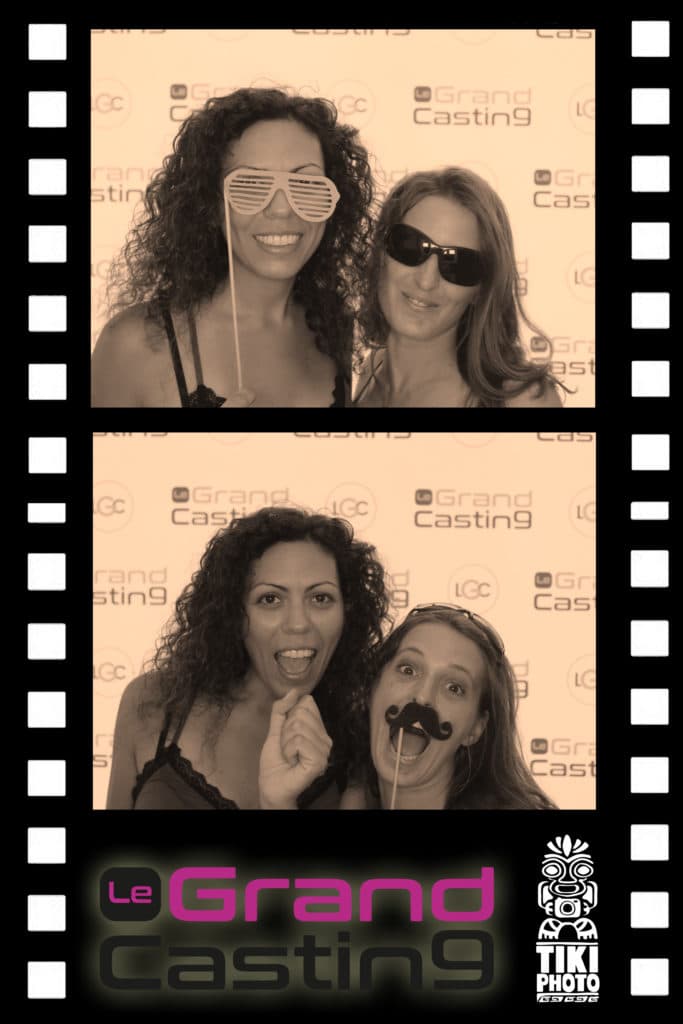 Two women are posing for a picture in a photo booth for le grand casting