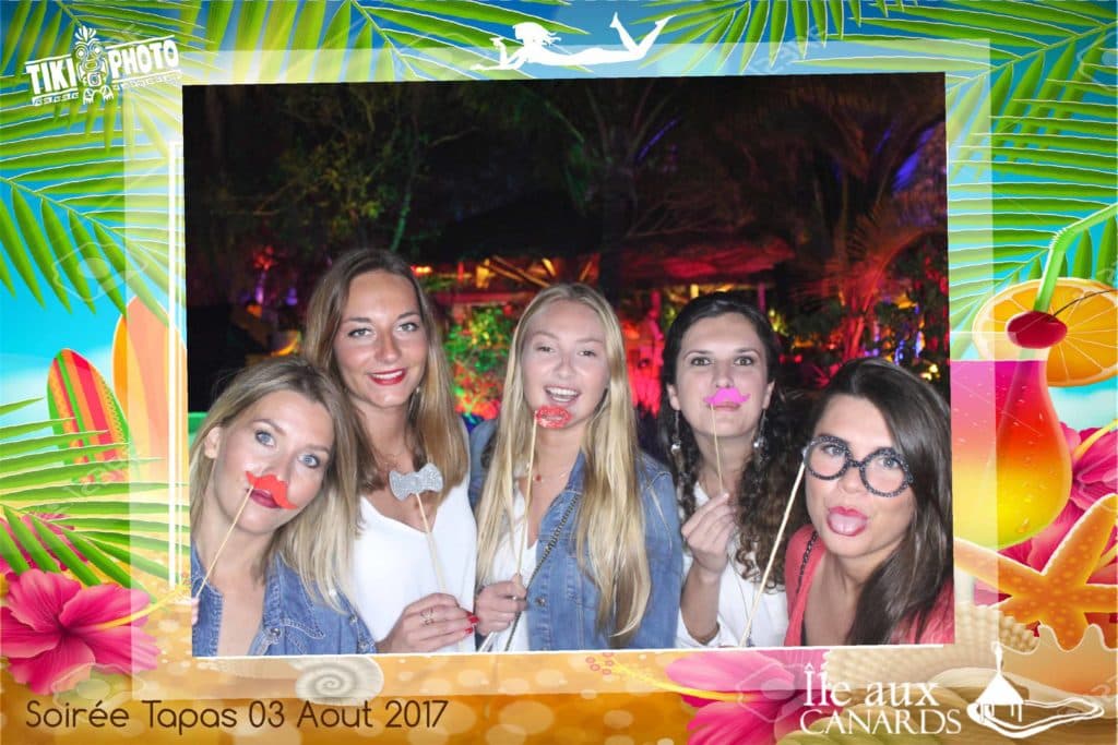 A group of women are posing for a picture in a photo booth.