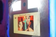A man and a woman are taking a picture in a photo booth.