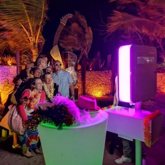 A group of people are posing for a picture in front of a photo booth.