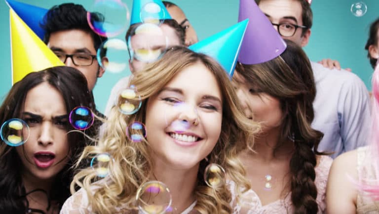 A group of people wearing party hats are posing for a picture.