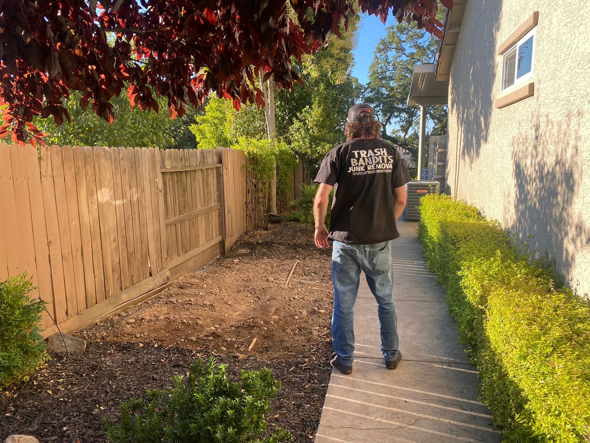 A man is walking down a sidewalk in front of a house.