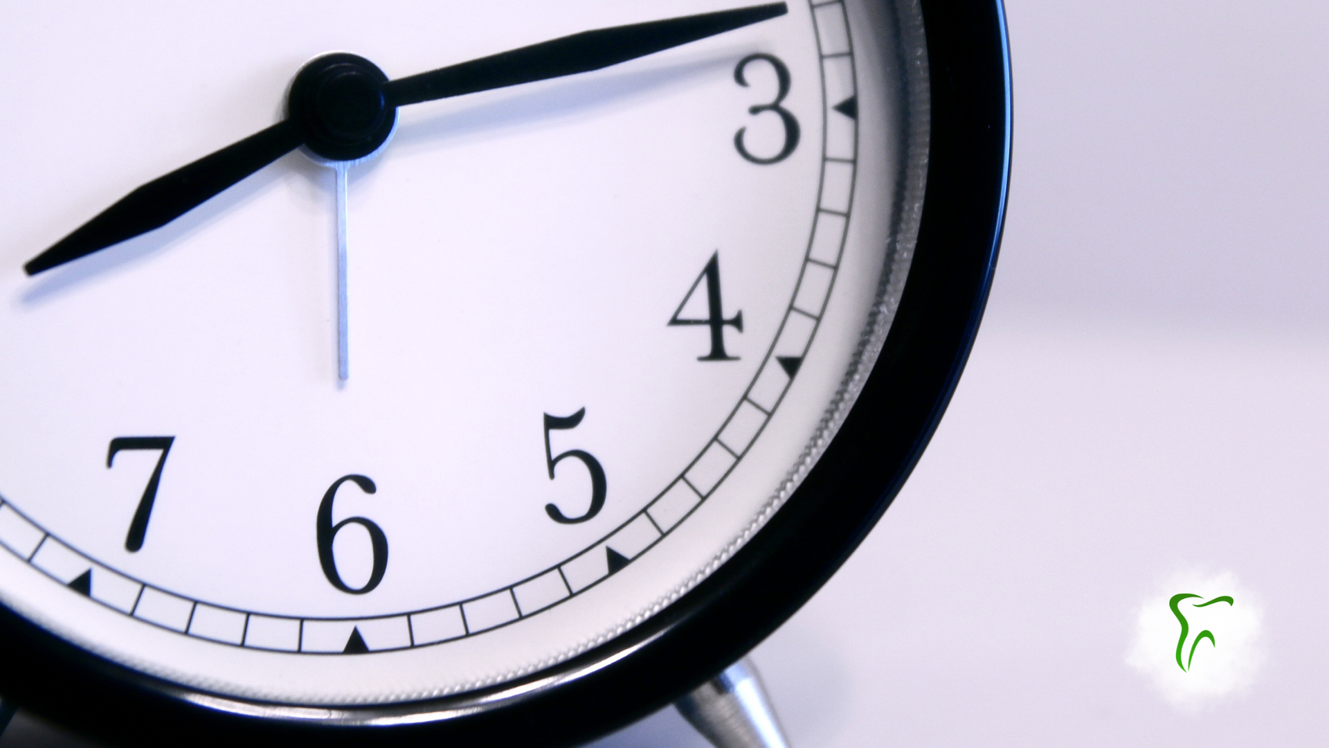 Clock showing time past 7:15. Black clock with white face.