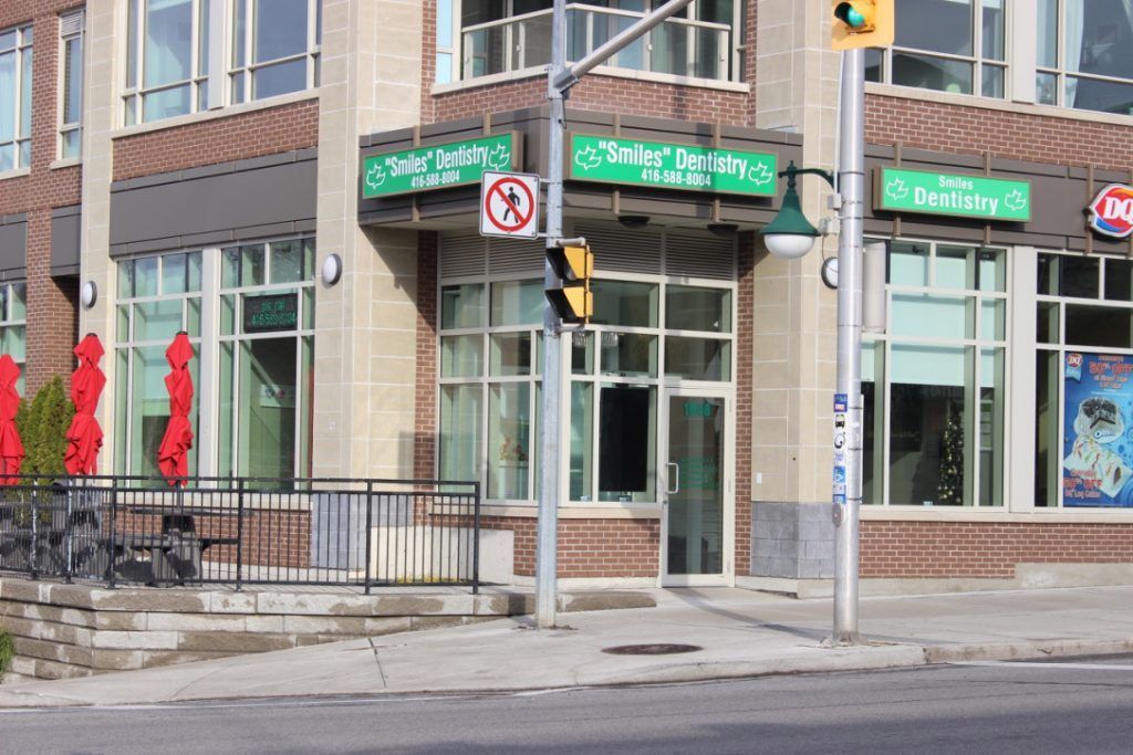 A brick building with a green sign that says no parking