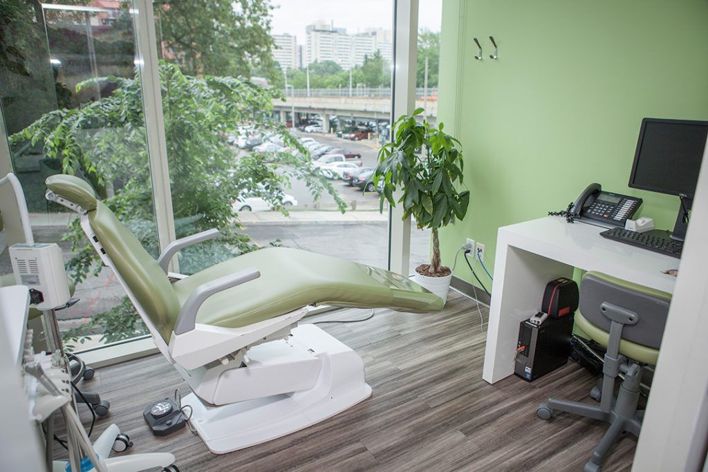 A dental office with a dental chair and a desk.