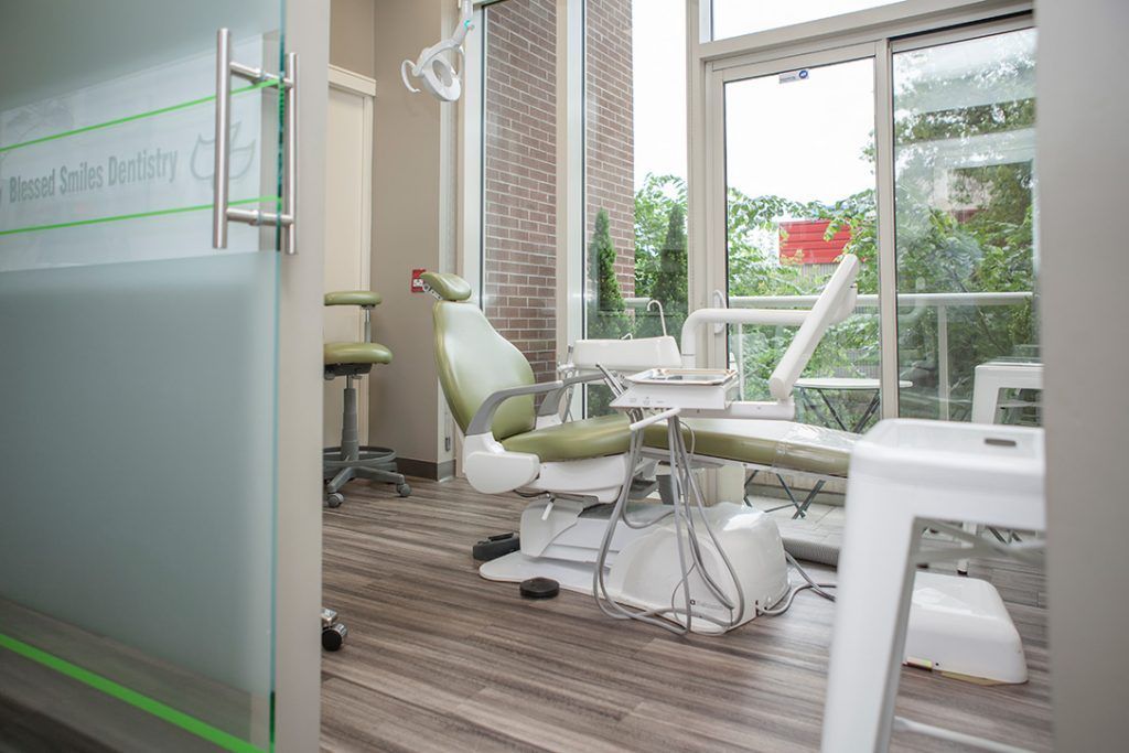 A dental office with a dental chair and a window.