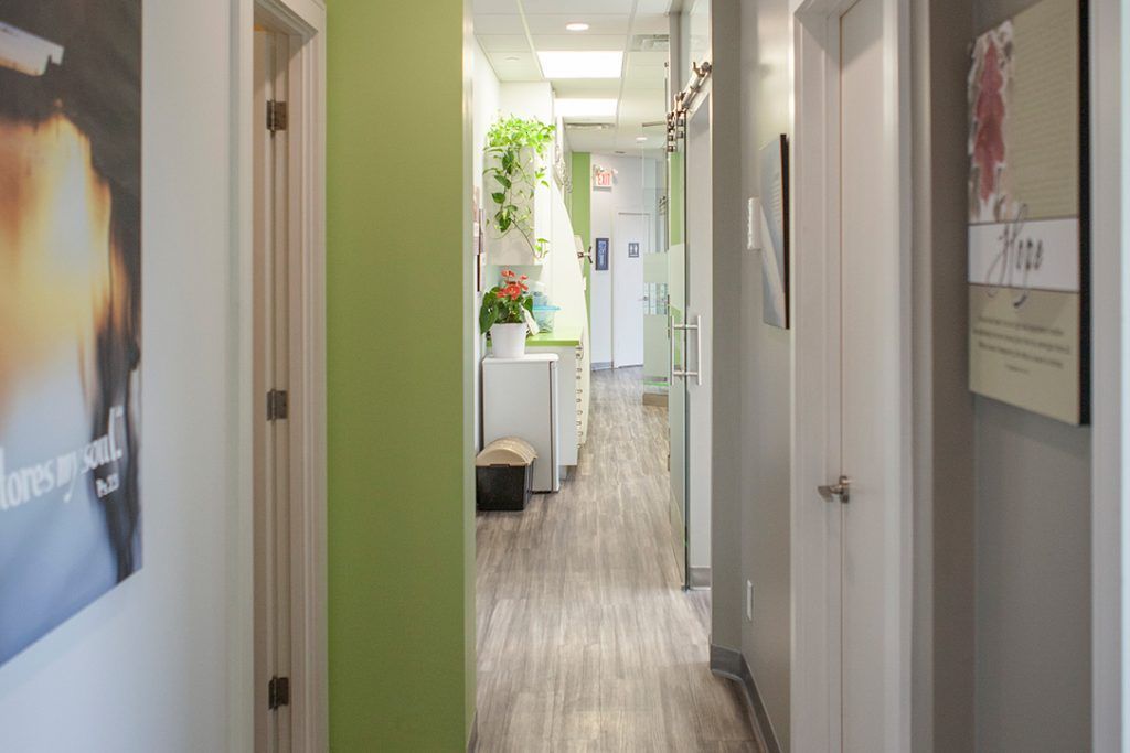 A hallway in a dental office with a sign on the wall.