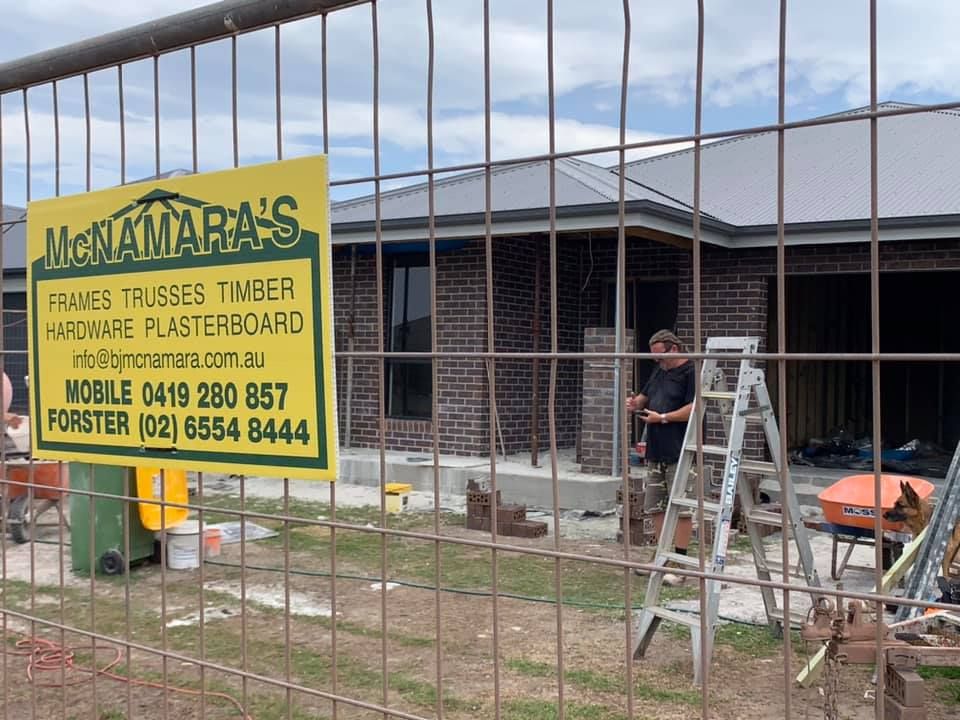 Construction Site With Green and Yellow Sign — McNamara's Frames & Trusses In Forster, NSW