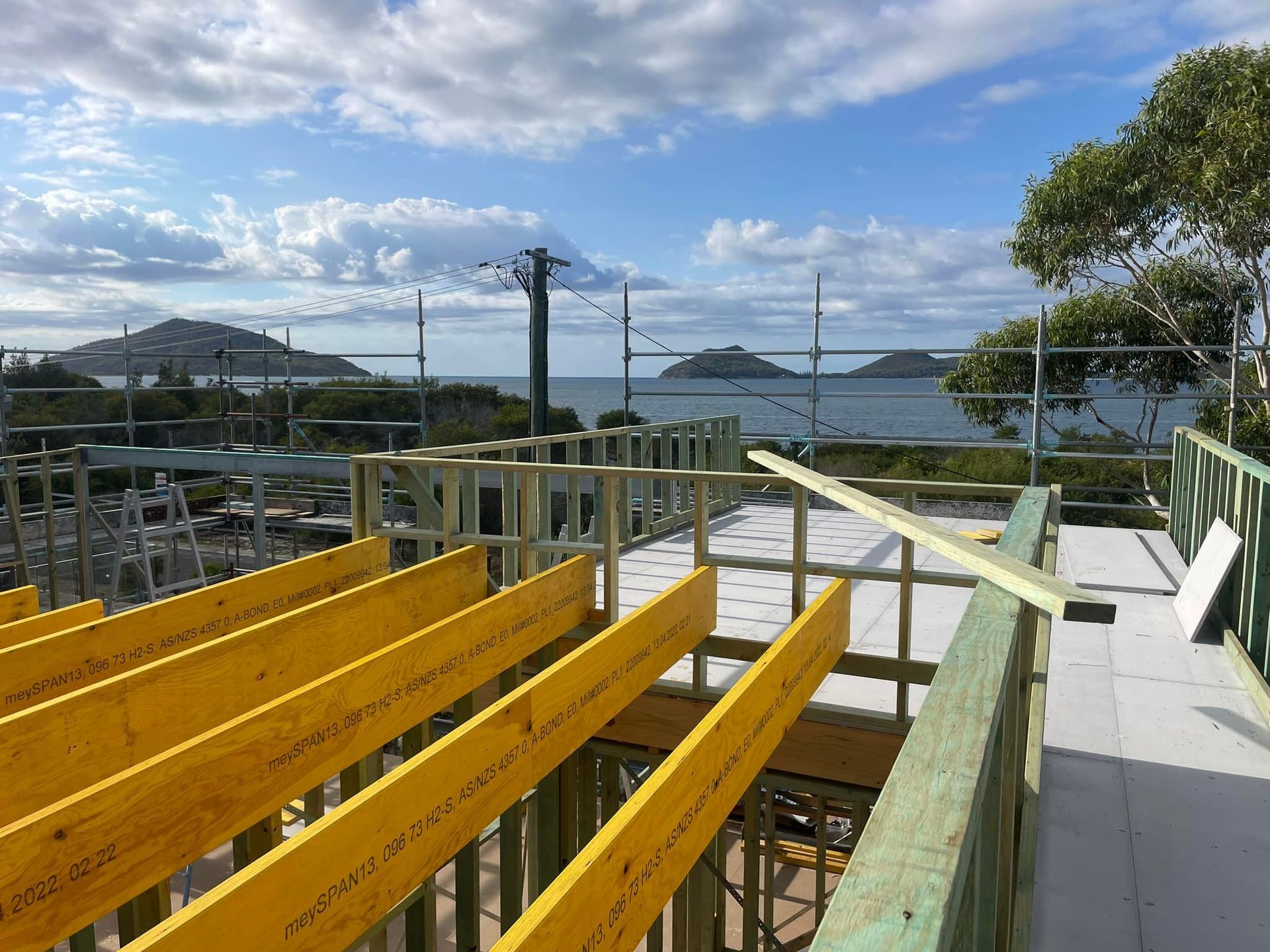 Construction Site With Yellow Beams and Ocean View — McNamara's Frames & Trusses In Gosford, NSW