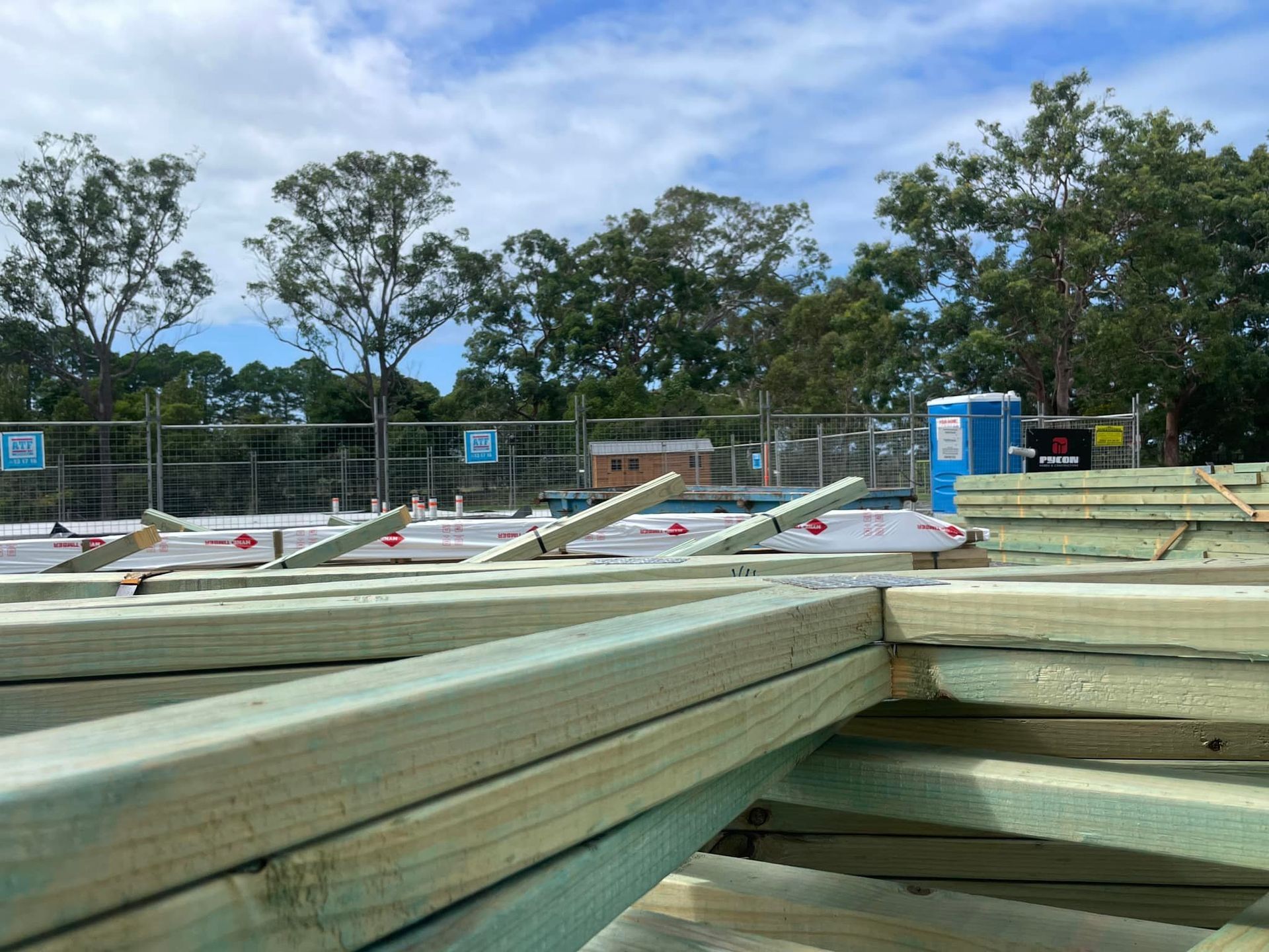 Construction Site With Wooden Beams in Foreground — McNamara's Frames & Trusses In Woy Woy, NSW