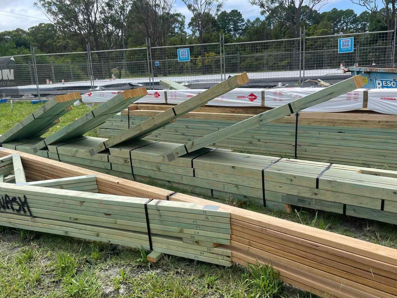 Stacks of Treated Lumber and Timber Trusses at a Construction Site — McNamara's Frames & Trusses In Central Coast, NSW