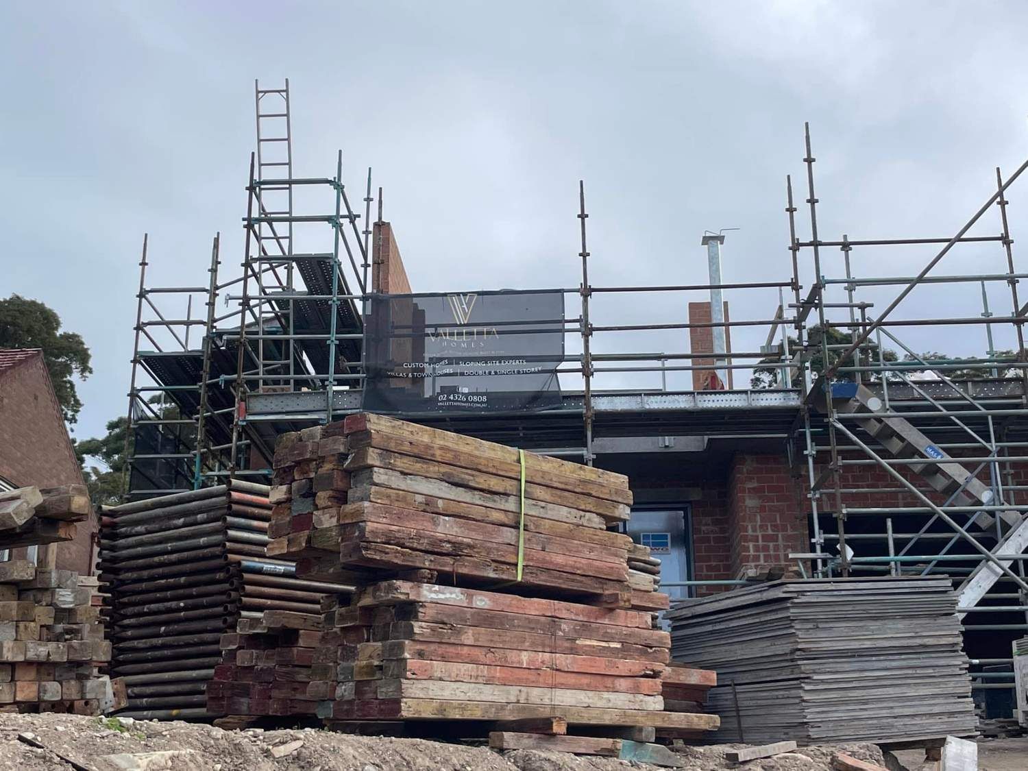 Construction Site With Scaffolding Around a Brick Building — McNamara's Frames & Trusses In Mid North Coast, NSW
