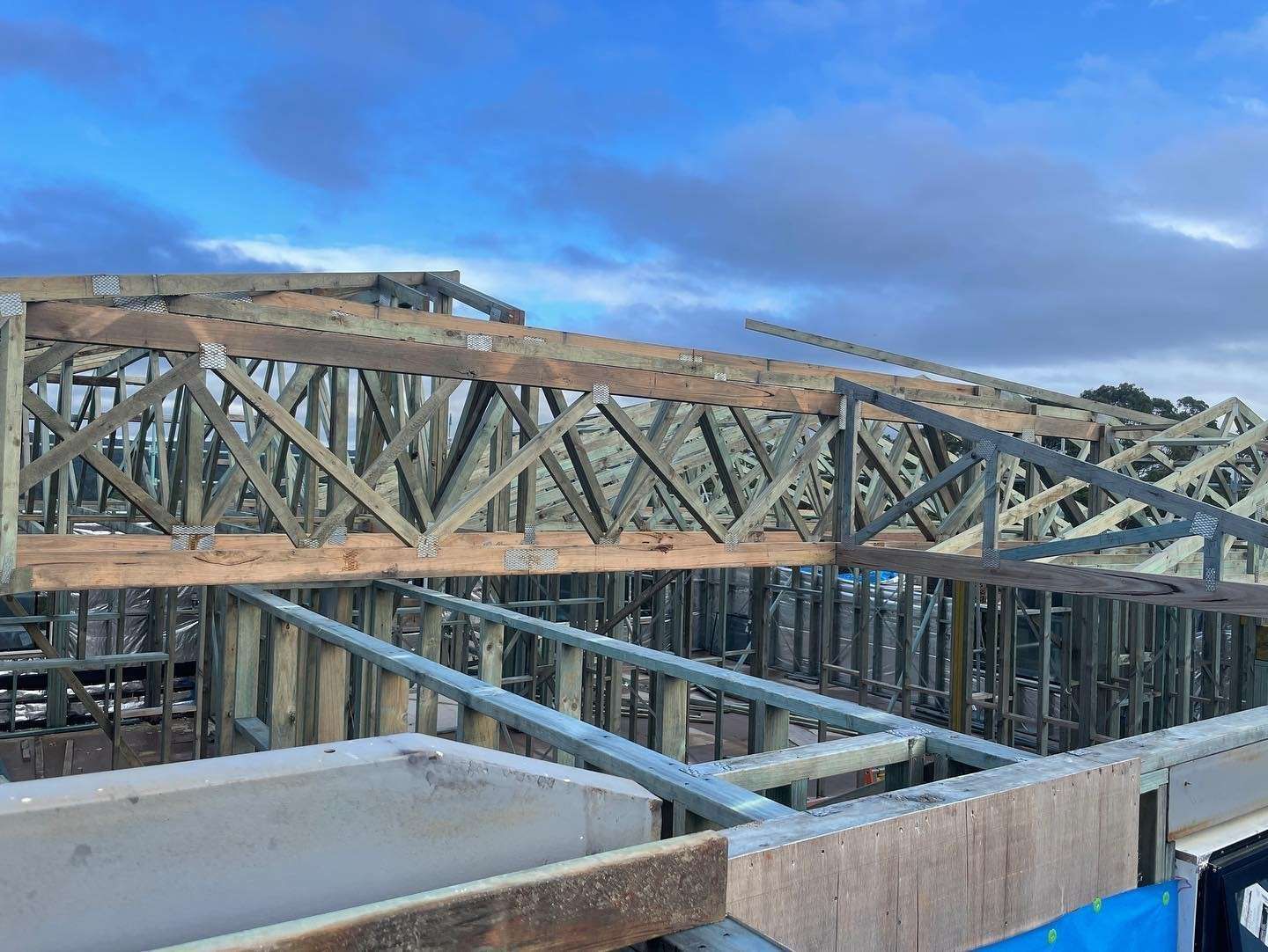 Wooden Roof Trusses Being Installed on a Construction Site — McNamara's Frames & Trusses In Terrigal, NSW