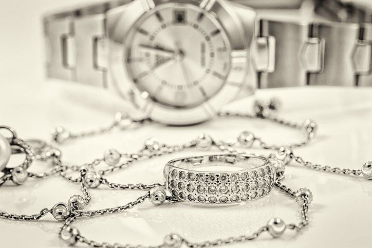 Silver ring and chain on the background of watches — Dunwoody, GA — WFN Enterprises